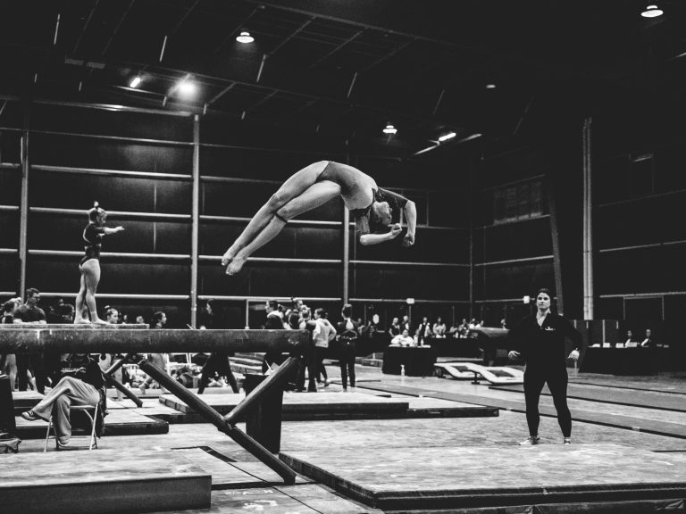 Greta Stowell, Level 10 gymnast from Olympus Gymnastics, performing on balance beam. Demonstrating precise balance and control, skills that 